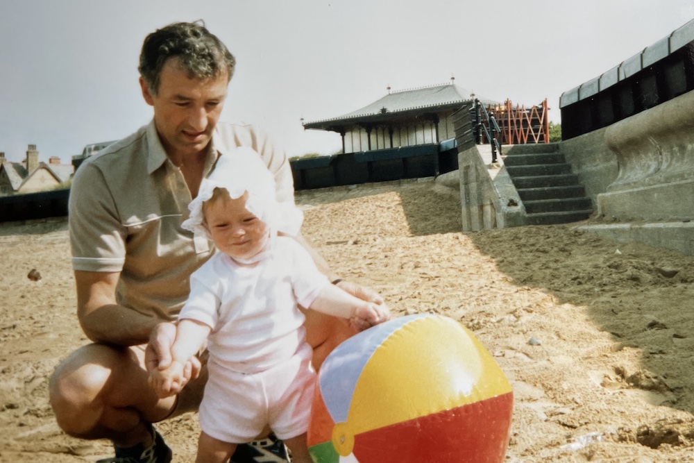 Dad and daughter at beach with a large beach ball